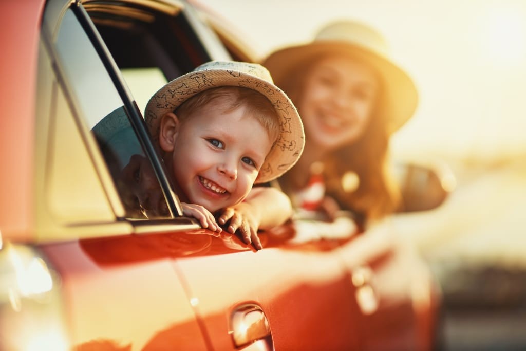 happy family mother and child boy goes to summer travel trip in car