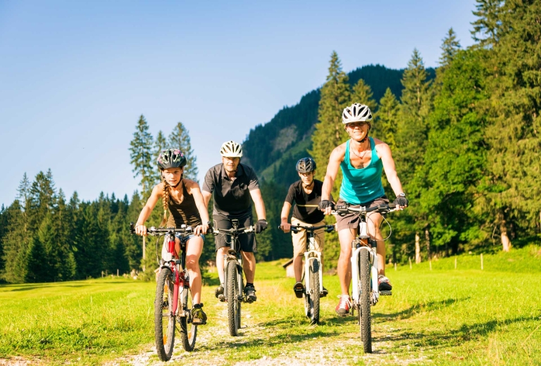 Familie beim Mountainbiken. Spannende Radstrecken finden Sie in unseren Familienhotels in Tirol direkt vor unserer Haustür.