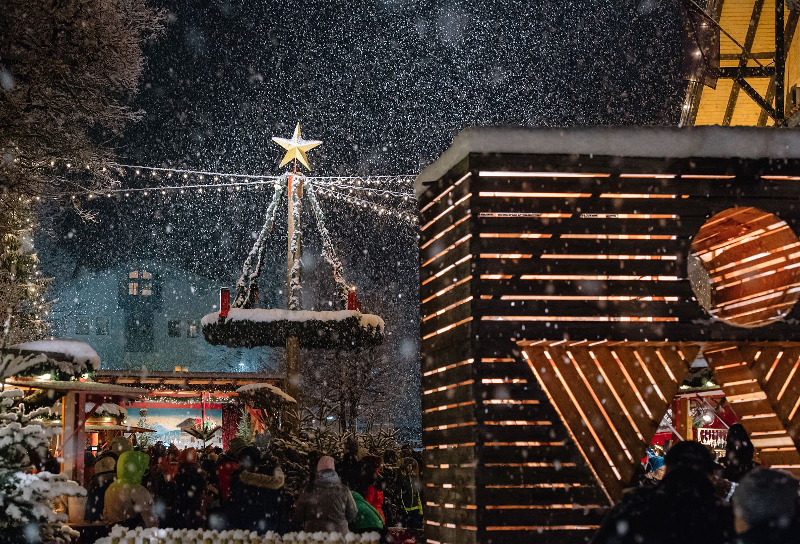 Dicke Schneeflocken und ein großer Adventskranz auf dem Marktplatz